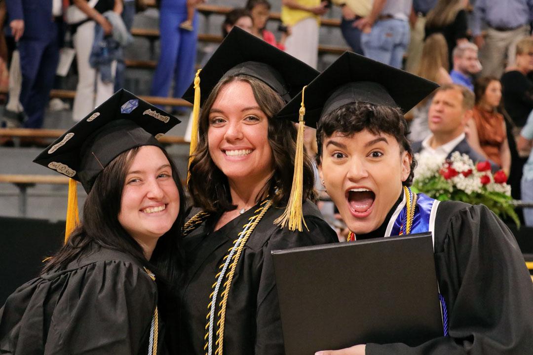 Excited students smile after receiving their diplomas
